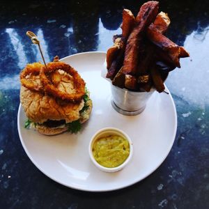 Veggie burger with beer battered onion rings. Vegan. at Crimson Rhino in Aberystwyth