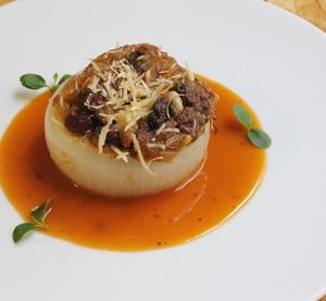 Cebolla dulce gratinada rellena de pasas y piñones con salsa de Madeira #vegan en #elvergeltarragona  at El Vergel Veggie Restaurant in Tarragona
