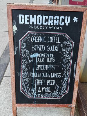 Sign says Proudly Vegan, but the restaurant serves 2% dairy milk and honey inside…  at Democracy* in Hamilton