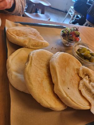 Pita bread with side salad, olives and pickles at Sir Hummus in Amsterdam