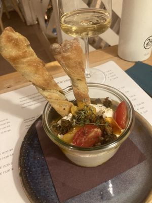 Alone ricotta with tomato confit and fried capers and homemade olive bread twists   at Romeow Cat Bistrot in Rome