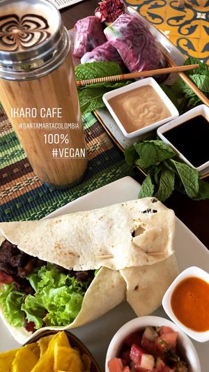 Burrito, almond milk latte and Vietnamese rolls @ edtatton85 on instagram  at Ikaro Cafe in Santa Marta