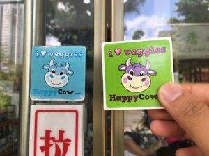 Old vs New HappyCow Stickers at Nature's Harvest Cafe in Central Singapore