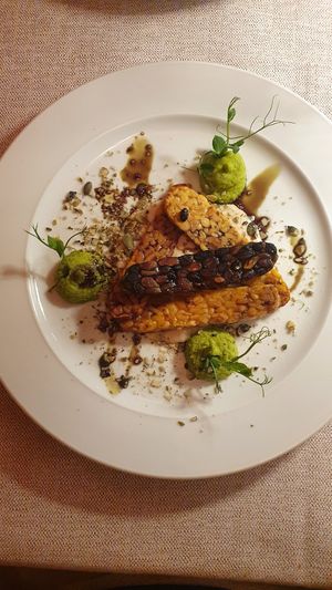 Tempeh fatto in casa di soia e arachidi friulane e di fagioli neri e pistacchi, servito con crema di cannellini al limone, crema di piselli, crema di semi di zucca e semi di zucca  at Al Tiglio Cucina Naturale in Moruzzo