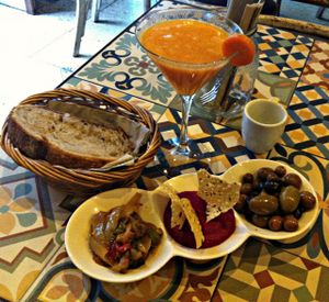 Three different types of tapas (olives, beetroth hummus and mixed veggies) and fresh juice at VEGA - Luna in Madrid