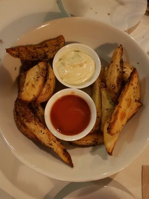 Potatoe wedges with aioli and spicy sauce at VEGA - Luna in Madrid