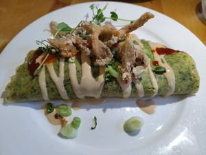 Spinach pancake filled with sweet potato, tofu, and pak choy; miso sauce and crunchy oyster mushrooms as a topping at Hagedis in The Hague