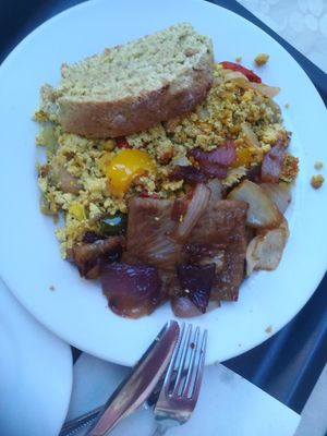 Seitan with onion, scrambled tofu and warm bread on the side at Edeni Vegan in Budapest