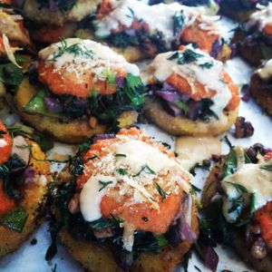 Polenta magic! Crispy polenta topped with pumpkin seeds, capers, sauteed veggies, carrot onion sauce and creamy miso sauce. Totally vegan! Special treat! at Kushi Institute in Becket