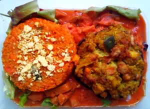 Seitan dish with vegan burgers on top at Sociedade Portuguesa de Naturalogia in Lisbon