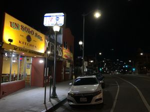 Store front at night and DTLA in the background   at Un Solo Sol in Los Angeles