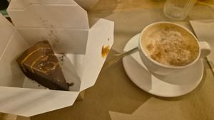 Chocolate cake to go as I was too full. Wonderful café con leche. at Punto Vegano in Madrid