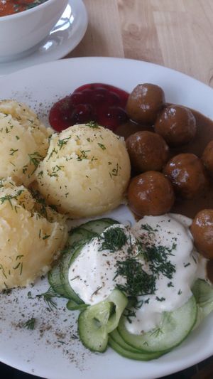 Potato puree with dill, cranberry sauce, cucumber salad and Polish version of meat balls - 'klopsiki'. The dish is called KLOPSIKI. at Lokal Vegan Bistro in Warsaw
