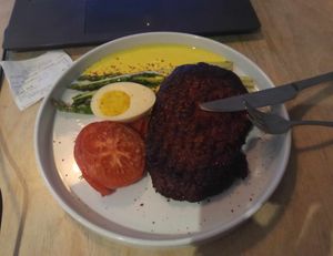 Seitan steak & plant-based egg, roasted tomato and asparagus at Lokal Vegan Bistro in Warsaw