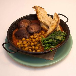 Vegan Shakshuka. Tofu, chickpeas & spinach baked in a sauce of spicy tomatoes inspired by a traditional Middle Eastern recipe. Served with pide bread. at Scarecrow in Auckland