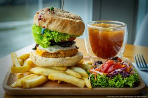 Lion’s Mane Extreme Burger with salad & fries and comes with a Lemon Passion Fruit Tea  at nomVnom Bistro - Clarke Quay in Central Singapore