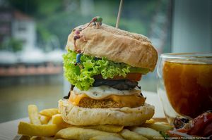 Lion’s Mane Extreme Burger with salad & fries and comes with a Lemon Passion Fruit Tea  at nomVnom Bistro - Clarke Quay in Central Singapore
