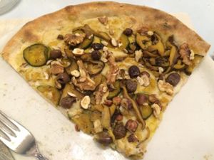 Pizza Namaste: Homemade soya cream cheese, sauteed courgettes, shiitake mushrooms, taggiasca olives, curry and dried fruit. at Pizzeria Capri in Jesolo