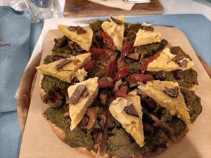 La fabbrica del mondo, pizza vegana con crema di cavolo nero, farifrittata di ceci e cipolla, pomodori secchi at Pizzeria Capri in Jesolo