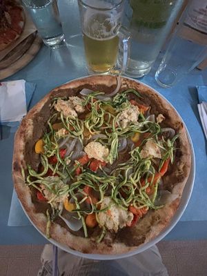 Pizza con crema di melanzane, falde di peperoni, cipolla ripassata, ricotta di mandorle alle olive verdi e carpaccio di zucchine marinate. at Pizzeria Capri in Jesolo