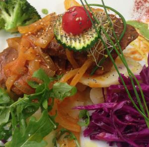 The delicious seitan steak with tomatoes and onions, served with a side of delicious potatoes and some fresh, salted cabbage  at Yerbabuena - Bordadores in Madrid