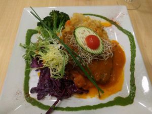 Homemade seitan steak with tomato and onion at Yerbabuena - Bordadores in Madrid