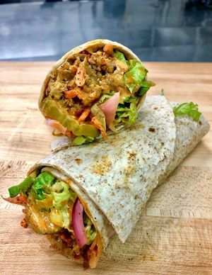 Vegan “Meatloaf” Wrap.  House made vegan “meatloaf” topped with salad and spicy pickles.  Very very good! at Juice Junkies in Keller