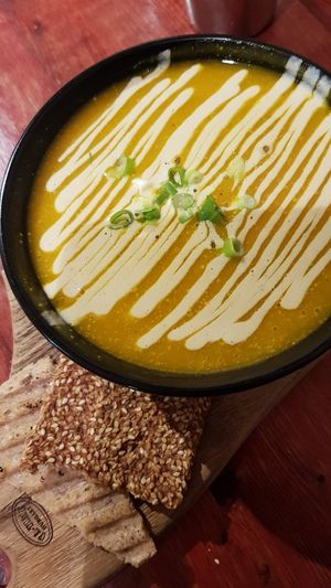 Pumpkin daily soup with a cracker and gluten-free bread at Indigo Age Cafe in Vancouver