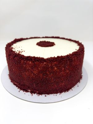A hugely popular light sponge flavoured with cocoa undertones and sandwiched with a mild tangy 'cream' cheese frosting, decorated with red velvet sponge crumbs. at The Free From Bakehouse in London