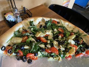 Design your own pizza - spinach, basil, olive, artichoke hearts, and cherry tomatoes. Olive oil and garlic sauce and Daiya cheese on their vegan crust. So delicious ! at Rosie's Pizzeria in Pagosa Springs