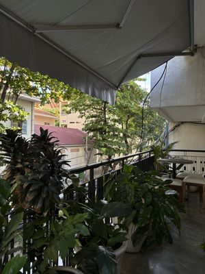 Upstairs patio with two small tables  at Backyard Cafe - Riverside in Phnom Penh