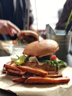 Seitan burger with sweet potato fries and special ordered tip on the side at GYVAS baras in Vilnius