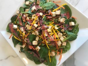 Spinach and Marinated Tofu Salad.   This protein packed salad comes with our homemade beet and coconut vinegar dressing.  A hearty portion that will not only fill you up, but will keep you going long after you are done. at LOVJuice in Boca Raton