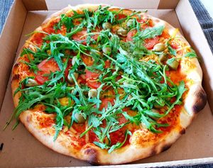 Pizza with vegan cheese, rocket, fresh tomatoes and olives at Fleischfrei in Dusseldorf