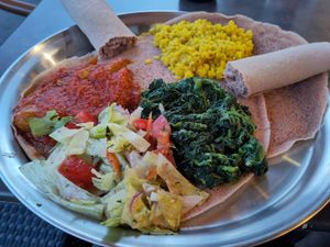 Vegetarian platter with yellow lentils, okra, spinach, salad and injera. at Saron in Heidelberg