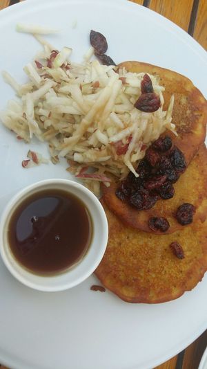 Vegan pancakes with apples, dried cranberries, and maple syrup. at Cafe Mlynek in Krakow
