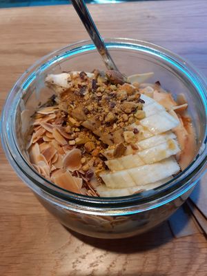 Banana maple syrup porridge with crushed nuts and toasted coconut. Super delicious at Cafe Neundrei in Berlin