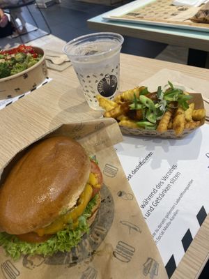 The „Cheesy One“ burger in a menu with canadian poutine fries. and homemade lemonade  at VINCENT - Europa Passage in Hamburg