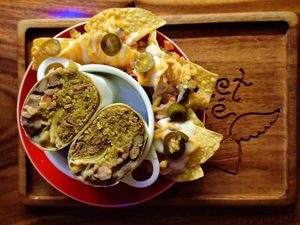 Our yum burritos are huge!  Surrounded by nachos & cheese. Vegan or Vegetarian. at The Kismet Cafe in Makati