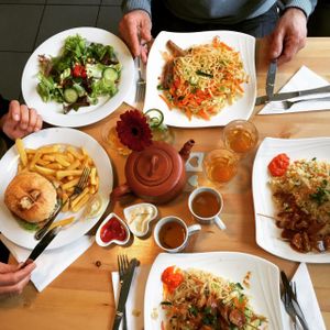 Selection of different dishes, like hamburger with fries and fried noodles with saté. at Loving Hut in Amsterdam
