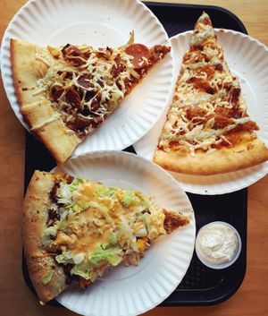 Pig Destroyer Destroyer (meat lovers, with BBQ sauce and garlic sauce), BBQ Buffalover, and Fat Mac (vegan Big Mac) slices, with garlic cream sauce for crust dipping. Photo taken March 2018. at Apiecalypse Now Pizza and Snack Bar in Toronto