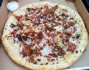 Pig Destroyer Destroyer pizza (with garlic dipping sauce)...creamy garlic sauce, hot sauce,
BBQ soy curls, seitan chorizo crumble and beef crumble, garlic artichokes, bacon bits, pepperoni slices,
mozzarella, and smoked Gouda. at Apiecalypse Now Pizza and Snack Bar in Toronto
