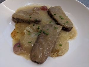 Seitan steaks on a bed of thinly sliced potatoes at Teresa Carles Cocina Vegetariana in Barcelona