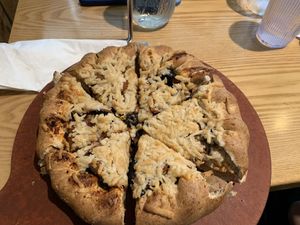 Thick wheat crust, dairy free cheese, plant based sausage/pepperoni, mushrooms, and black olives at Beau Jo's in Fort Collins