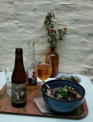 Bowl with noodles and kimchi, beer, cider, and Moroccan carrots with olives. at Le Botaniste in Ghent