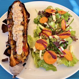 Baked sweet potato stuffed with vegetables topped with aioli and nuts gratin + salad  at Fang i Aram in Menorca
