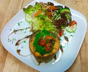 Sweet potato ship with spinach, chickpeas, cherry tomatoes and lime tahina on salad  at LOLA was here in Berlin