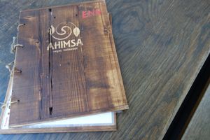 The menu bound in wood at Ahimsa Vegan Restaurant and Club in Wroclaw