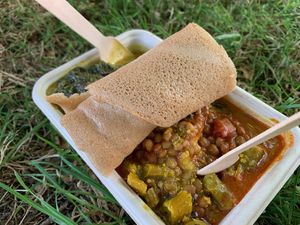 Box with a range of curries, spinach, sauces etc, cous cous and injera   at Red Tent Ethiopia in South East London