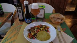 A burger with a quinoa base and several veggies mixed in (corn, broccoli, carrots, etc.) with sauteed veggies on the side, and an organic saison beer. at V-Bar Natural in Parma